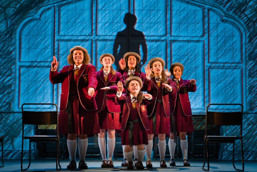 girls on stage in a school uniform